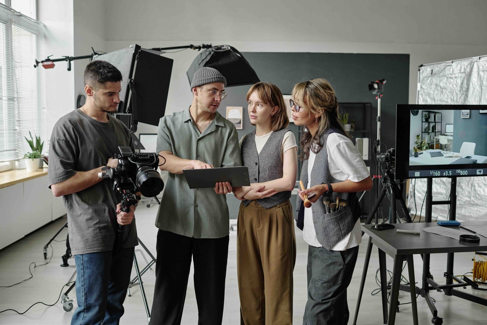 Crew Discussing Shooting Day Director showing script and discussing details of shooting day while his best cameraman sitting device